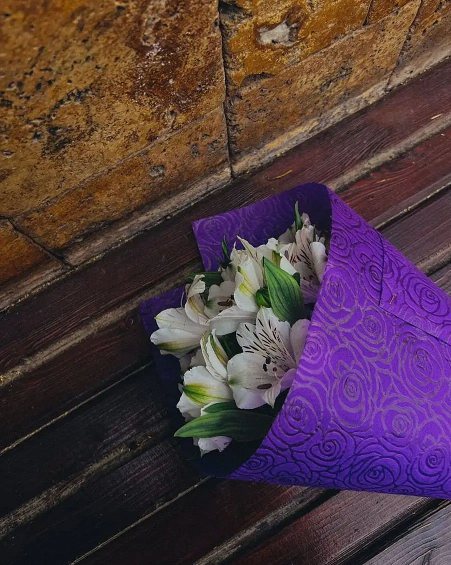 White alstroemeria bouquet in purple wrapping (illustrative photo)